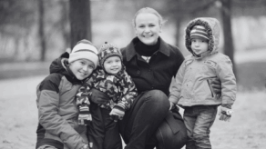Happy woman with three children smiling towards the camera